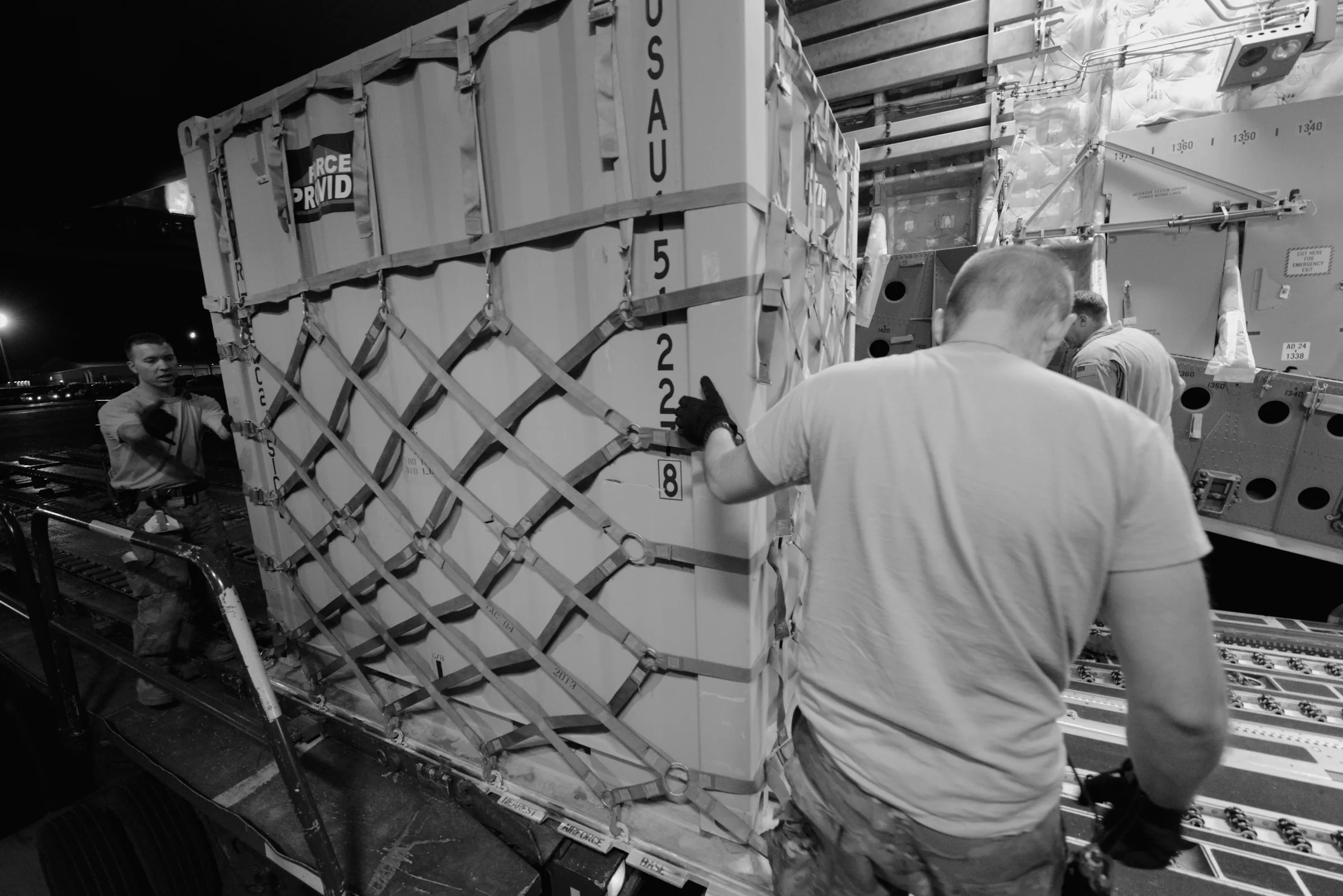 Cargo loading at airfield at dusk, editorial b&w